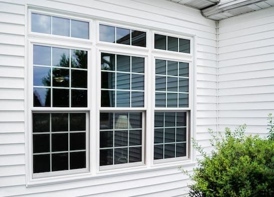 Exterior view of residential double-hung windows with intact screens