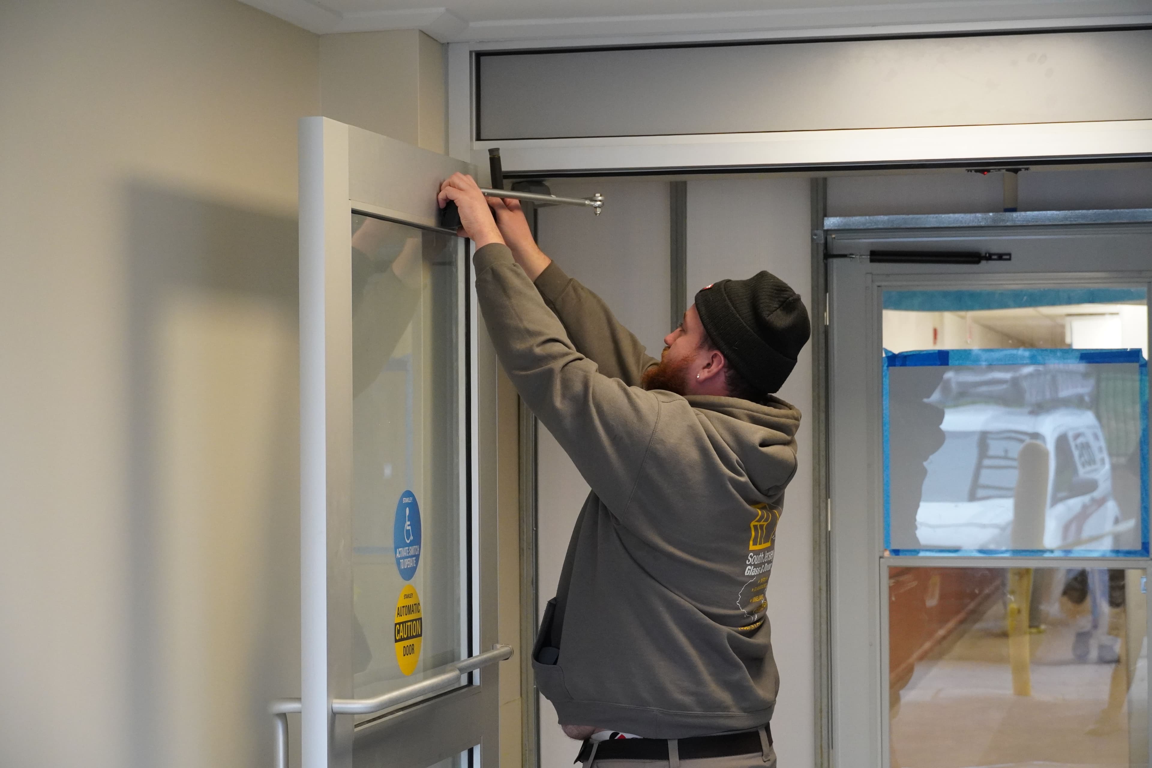 South Jersey Glass and Door technician repairing an automatic operator on automatic door